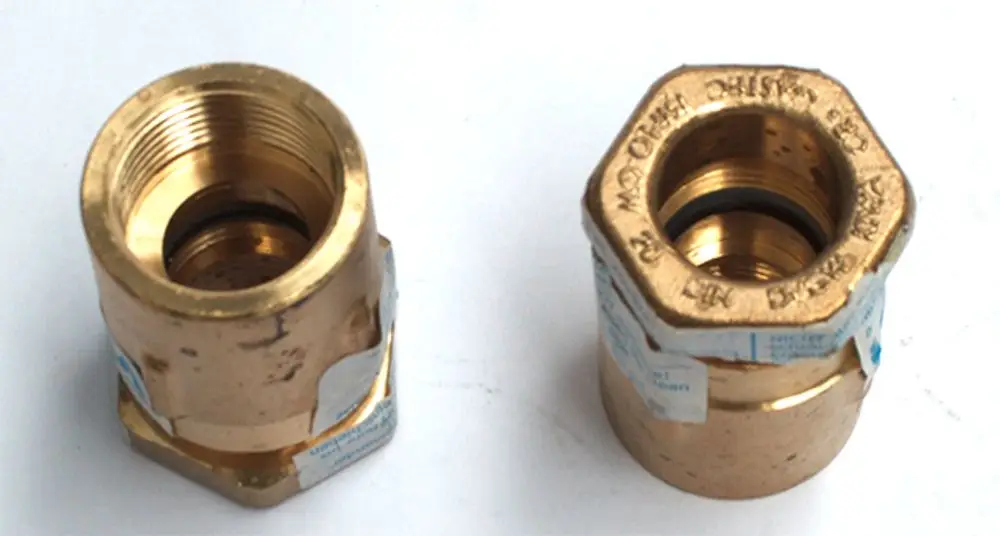 Zwei Metallarmaturen in goldener Farbe, mit Innengewinde, geeignet für Anschluss an Heiz- oder Kühlsysteme, erkennbar als Zubehör von Daikin.